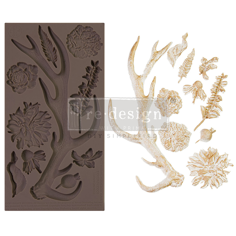 Silicone casting mould featuring a large deer antler surrounded by detailed botanical elements including flowers, leaves, feathers, berries, and floral stems. Beside the mould are examples of the finished cast pieces in a metallic gold finish, arranged individually to show the intricate textures and woodland-inspired decorative design.
