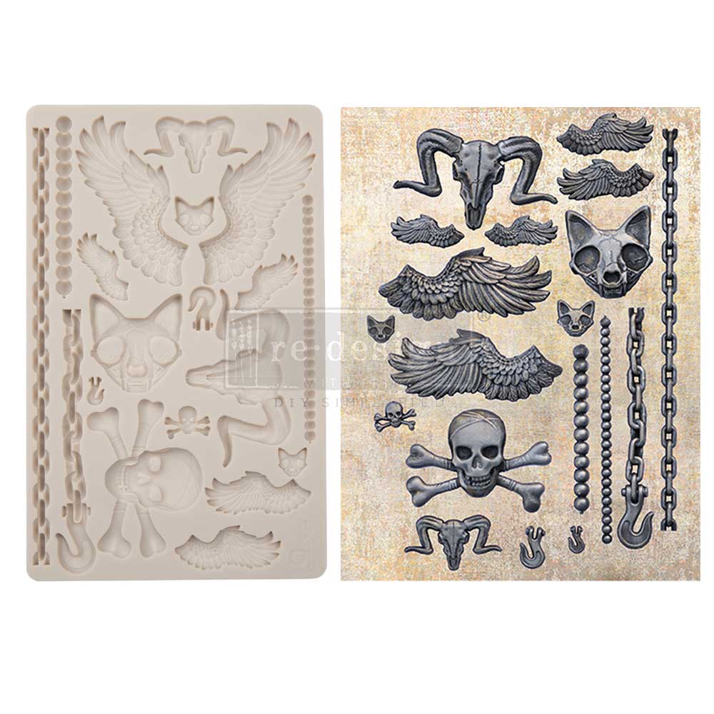 A side-by-side product display features a cream-colored silicone décor mold on the left and finished gothic-themed cast embellishments on the right against a light neutral background. The mold contains a variety of fantasy and underworld-inspired elements, including feathered wings, skulls, animal skull motifs, chains, beads, hooks, and small decorative accents. On the right, the completed castings are painted in dark metallic gray and black tones with dramatic shading that emphasizes their sculpted texture