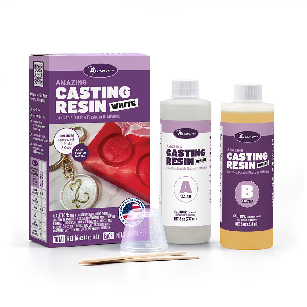 Alumilite Amazing Casting Resin White kit featuring Part A and Part B bottles, mixing cups, stir sticks, and product box for fast-curing white casting resin used in molds, jewelry, crafts, and DIY projects.