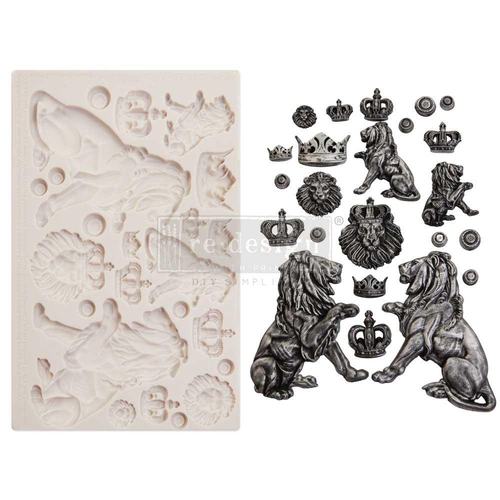 A side-by-side product display features a white silicone décor mould on the left and finished cast embellishments on the right. The mould contains detailed cavities shaped like regal lions, ornate crowns, lion heads, medallions, and decorative circular accents. The finished cast pieces are painted in antique silver and black metallic tones, emphasizing the sculpted textures and dramatic shadows. The arrangement includes large seated lions with flowing manes, smaller lions, crowned lion heads, and various ro
