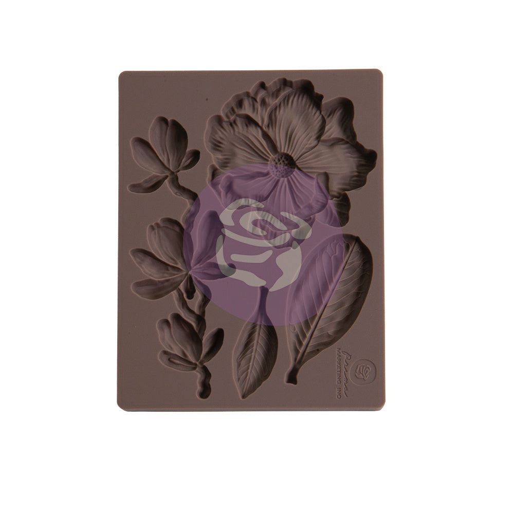 Flexible silicone mould featuring recessed botanical designs, including a large flower bloom, curved flowering stem, and textured leaves. The mould is dark taupe/brown and intended for casting decorative embellishments in resin, clay, plaster, or similar craft materials.